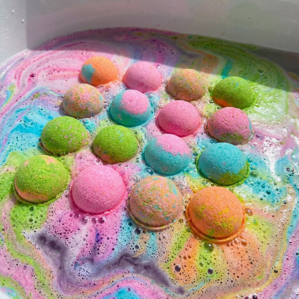 Colourful sphere bath bombs fizzing in bath water